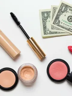 Budget makeup products flat lay with money