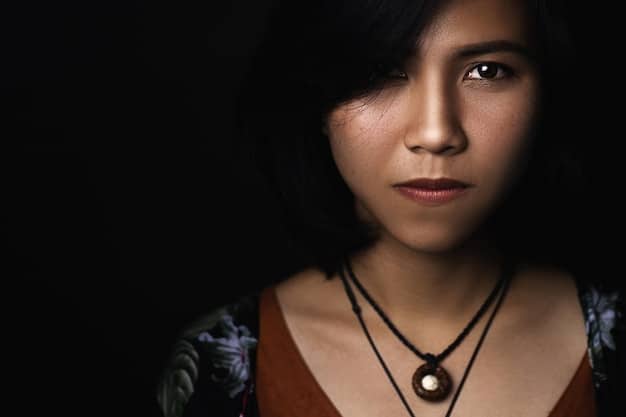 A close-up shot of an actress in a Korean drama, with dramatic lighting emphasizing her tearful expression. The lighting is dim and focused, creating strong shadows that highlight the contours of her face and the emotion in her eyes, effectively conveying sadness and vulnerability.