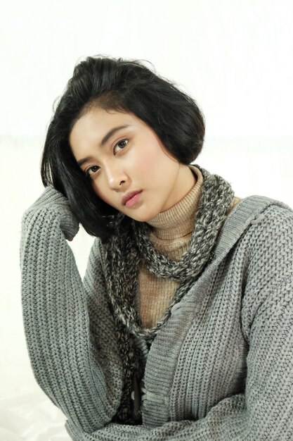 A young and stylish Korean actress with bright eyes and short hair, looking directly at the camera with a confident smile. She's wearing modern, trendy clothing, and the background is a vibrant cityscape at night.