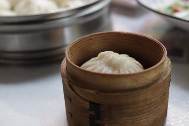 A close-up shot of perfectly steamed dumplings (jiaozi) in a bamboo steamer, with delicate pleats and a glistening sheen. The background is softly blurred, highlighting the intricate details of the dumplings and evoking a sense of warmth and comfort.