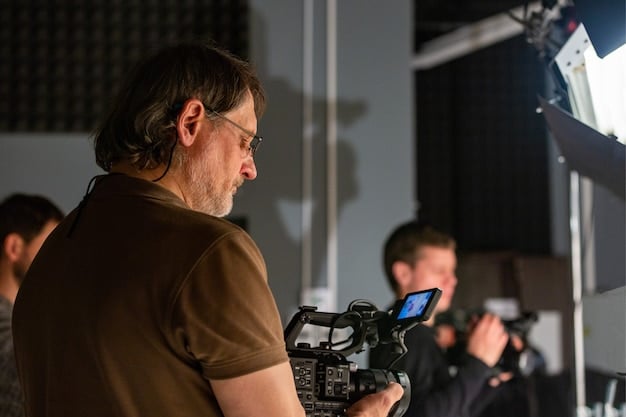 A close-up shot of the director, intensely focused, reviewing footage on a monitor during filming. The background is slightly blurred, highlighting the director's concentration and dedication.