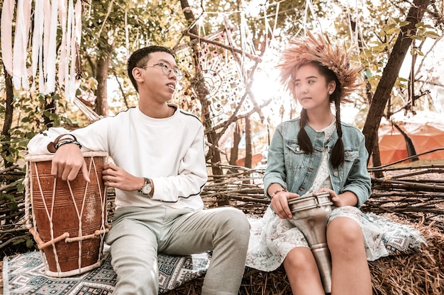 Two main characters from a modern-day Chinese drama share a quiet moment. They are sitting on a rooftop overlooking a bustling city, deep in conversation. The soft lighting emphasizes the intimacy of the scene, highlighting the emotional connection between them.