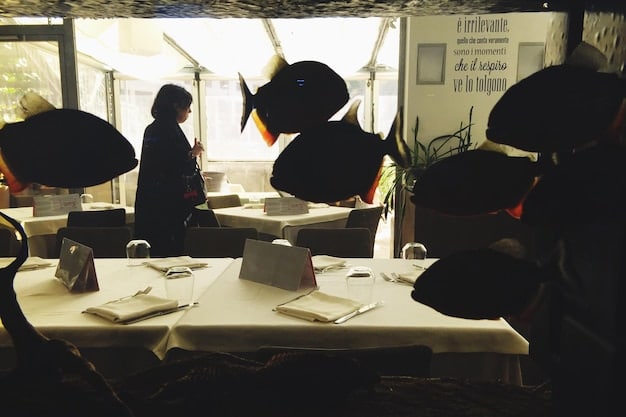 A candid shot of an office scene from a Japanese drama, featuring a group of coworkers gathered around a table, looking stressed and overworked, capturing the essence of Japanese corporate culture.