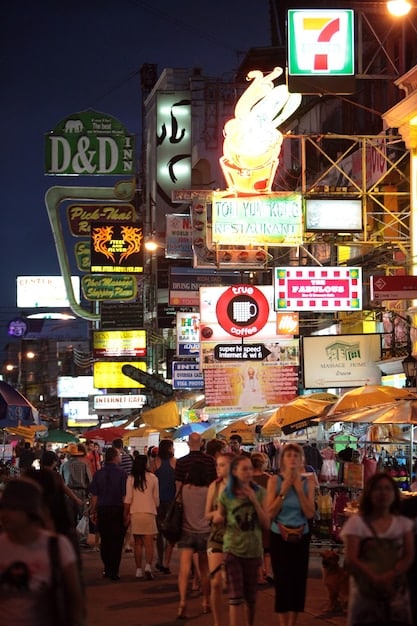 The vibrant Dotonbori district of Osaka at night. The iconic Glico Running Man sign shines brightly, and crowds of people are enjoying the street food and bustling atmosphere.