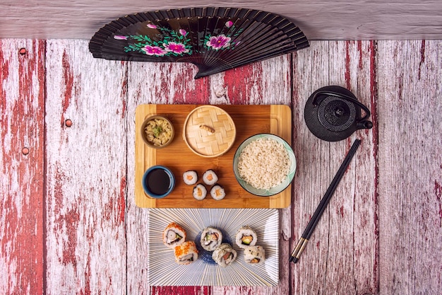 Uma foto de close-up mostrando uma variedade de ingredientes japoneses essenciais, como diferentes tipos de molho de soja, pasta de missô, dashi em pó e folhas de nori, dispostos em uma mesa de madeira rústica.