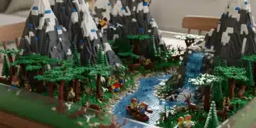 Lego diorama featuring realistic mountains, river, and trees